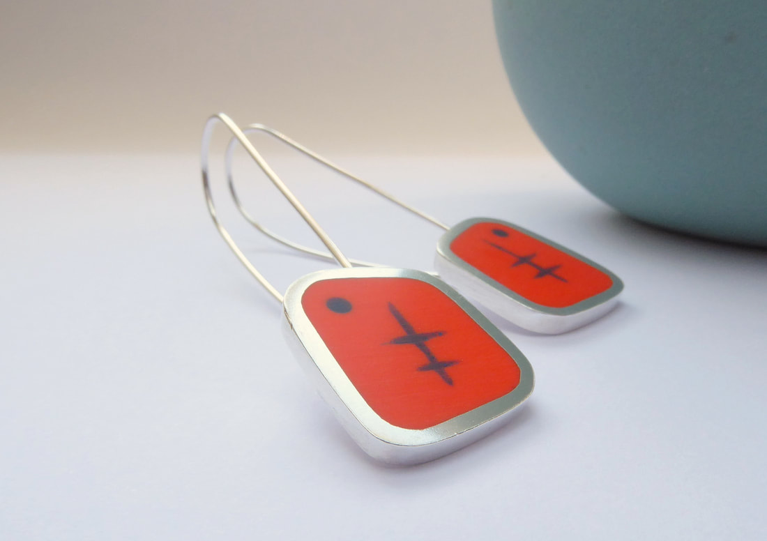 Picture of fifties style rectangular earrings with atomic design in resin and silver