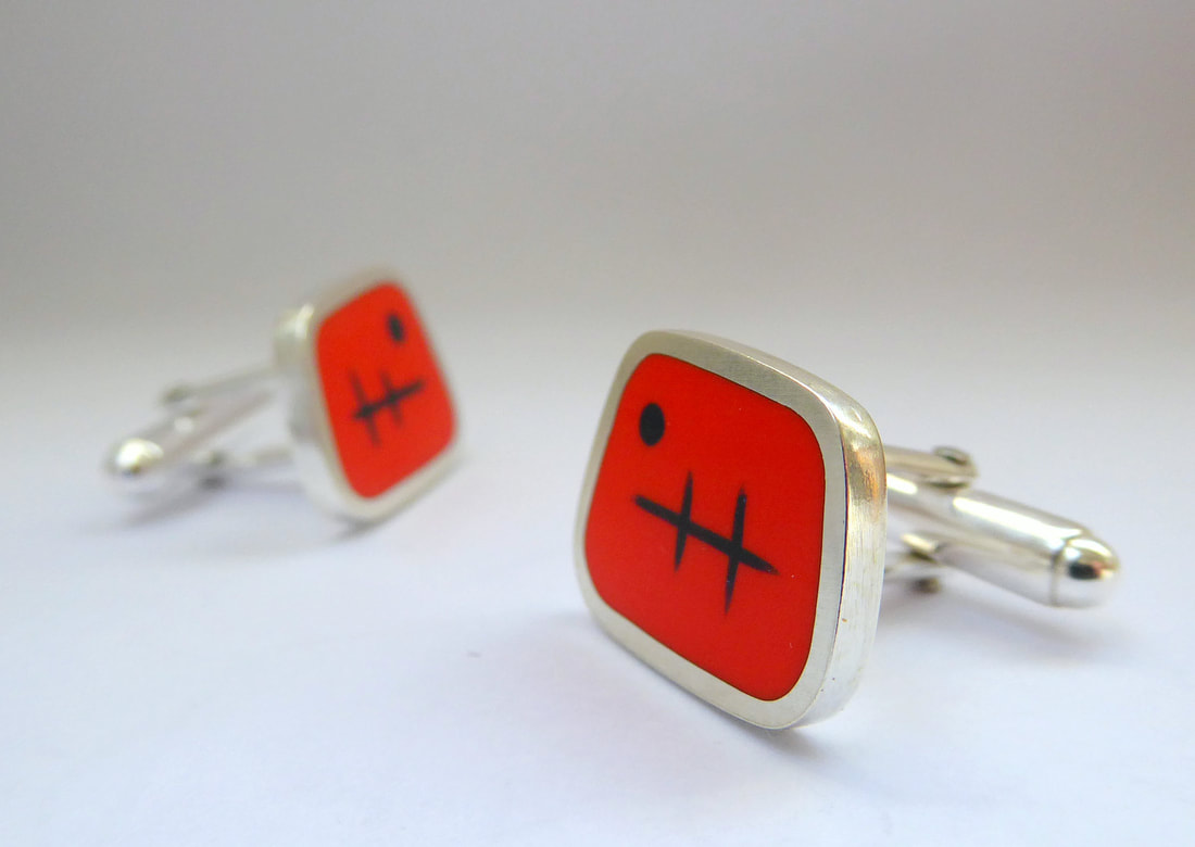 Picture of a pair of mid century style cufflinks in orange resin and silver